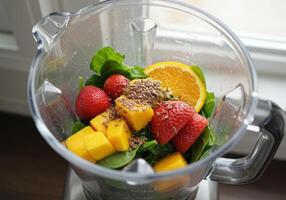 Fresh fruits and greens are placed inside a blender ready to make a smoothie. photo