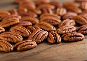 A collection of fresh, shelled pecan halves are displayed on a rustic wooden surface. photo