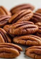 A pile of fresh, brown pecans fills the frame, displaying their textures and details up close. photo