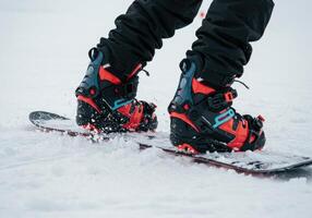 Snowboard boots and board ready for action on a snow covered slope. photo