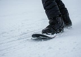 A snowboarder in action, carving through the fresh snow in the winter landscape. photo