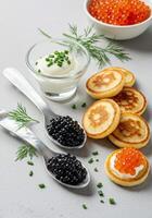 An elegant arrangement of caviar and blinis with accompaniments ready to serve. photo