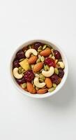 A vibrant and appetizing trail mix of nuts and dried cranberries in a white bowl. photo