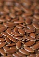 A pile of flax seeds filling the frame, exhibiting a warm brown hue in this close-up. photo
