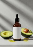 A brown bottle with a blank label, fresh avocado halves, and oil droplets on a surface. photo