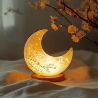 Crescent Moon Lamp Glowing with Cherry Blossoms on Bedside Table Creating a Warm and Tranquil Atmosphere for Relaxation and Serenity in Bedroom at Night photo
