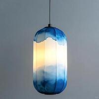 Elegant blue watercolor pattern lantern hanging, casting a warm and inviting glow in a modern interior, showcasing artistic design and creating a serene ambiance for home decor photo