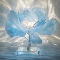 Elegant Blue Flower Sculpture on Glass Base Reflecting Light Patterns Creating a Serene Atmosphere in a Modern Setting with Artistic Design and Decorative Appeal photo