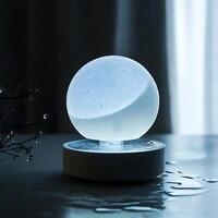 Illuminated moon humidifier emitting cool mist on surface creating tranquil atmosphere in dim room, promoting relaxation and sleep aid, enhancing overall well being photo