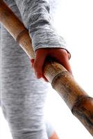 Close Up of Hands Holding a Thick Bamboo Pole Against White Background photo