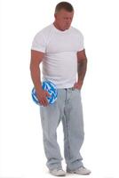 Muscular Man with Tattoo Holding Blue Juggling Ball Against White Background photo
