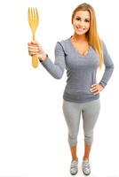 Smiling Woman Holding Large Wooden Fork in Studio photo