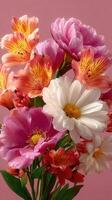 Colorful bouquet of fresh flowers including peonies and lilies arranged on a soft pink background photo