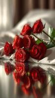 Red roses elegantly arranged on soft fabric with reflections in the background photo