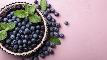 Homemade Blueberry Pie with Mint on Pink Background photo