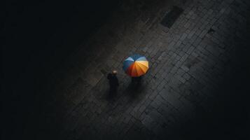 Couple Walking Under Colorful Umbrella On Cobblestone Street photo