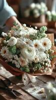 Beautiful bouquet of white flowers being prepared in a floral workshop in the early afternoon photo