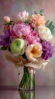Beautiful bouquet of fresh flowers featuring peonies, ranunculus, and seasonal blooms in a clear vase photo