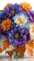Beautiful autumn flower arrangement with purple, orange, and white blooms in a clear vase photo
