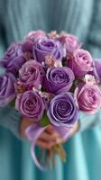 Bouquet of purple and lavender roses held by a person in a cozy sweater photo