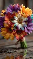 Brightly colored flower bouquet with raindrops on petals on rustic wooden surface photo