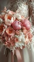 Delicate bridal bouquet featuring pink and coral flowers with soft greenery, captured in intimate setting before wedding ceremony photo