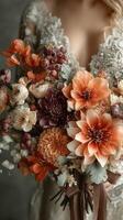 Elegant floral bouquet held by bride in autumn setting featuring warm colors and natural textures at a wedding celebration photo