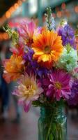 Brightly colored flower bouquet in a glass jar captured at a bustling market during daytime photo
