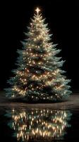 Festive Christmas tree adorned with lights and ornaments reflecting beautifully in the dark setting photo