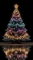 Colorful Christmas tree with glowing lights and ornaments set against a dark background photo