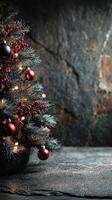 Christmas tree adorned with red ornaments and lights against a textured stone background creates a festive atmosphere in wintertime photo