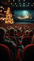 Audience enjoys holiday-themed performance in a cozy theater with festive decorations in the background photo