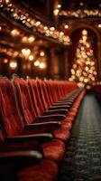 Elegant red theatre seats line the aisle adorned with soft lights and a sparkling Christmas tree during a festive evening event photo
