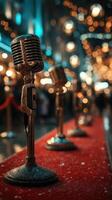 Vintage microphones line a red carpet at a glamorous evening event in a bustling city adorned with lights photo