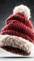 Cozy red knitted hat with fur trim floating against a snowy backdrop during winter season photo