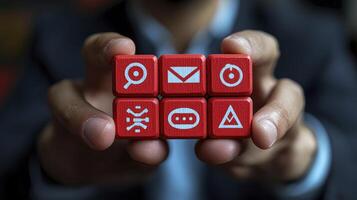 A person holding red cubes with icons on them photo