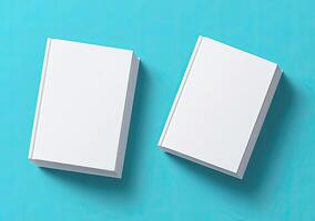 Two blank white books on teal background photo