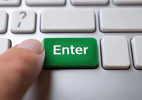 A person is pressing the enter button on a keyboard photo