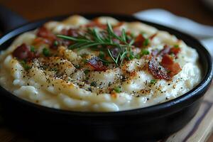 Creamy Mashed Potatoes Topped with Bacon and Herbs in a Black Skillet photo