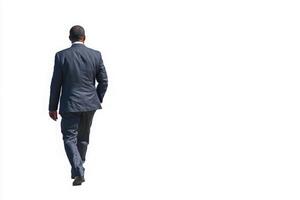 A man dressed in a dark suit is seen walking away. The bright background emphasizes his silhouette. He appears focused and determined, leaving a professional impression. photo