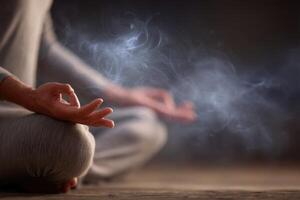 A person is meditating in a calm atmosphere, surrounded by a soft haze of smoke. The setting is dimly lit, creating a peaceful and introspective mood during twilight. photo