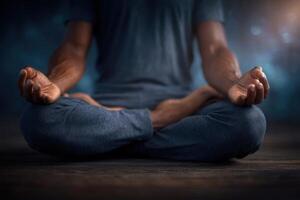 A person sits cross-legged on a wooden surface, practicing meditation. The hands rest on knees in a mudra position, while a calm and tranquil atmosphere surrounds them. photo