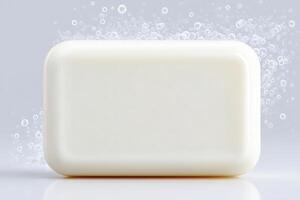 A plain white soap bar rests on a smooth surface, surrounded by floating bubbles that emphasize cleanliness and freshness. The soft gray background adds a soothing touch to the composition. photo