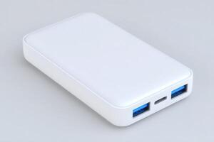 A sleek white portable charger with two USB-A ports and one USB-C port rests on a light background. Ideal for charging devices quickly while traveling or during outdoor activities. photo