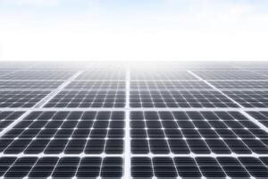 Rows of solar panels stretch across a flat surface, absorbing sunlight beneath a bright blue sky. This renewable energy setup showcases sustainable technology and efficiency. photo