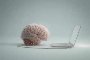 A brain model is positioned next to an open laptop. A cord connects the two, illustrating the relationship between human cognition and technology. The background is plain, emphasizing the subjects. photo