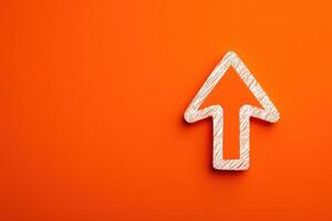 A vibrant orange surface features a prominently displayed white arrow outline that points upwards. The design is simple yet striking, drawing attention to the upward direction. photo