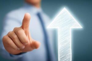 A persons hand is extending forward, pointing at a glowing arrow that symbolizes upward motion. photo
