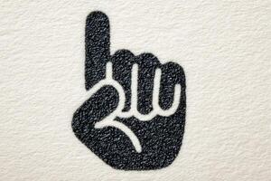 A hand is depicted with one finger raised, indicating silence or a warning gesture. The design features a textured background that enhances the visual appeal. photo