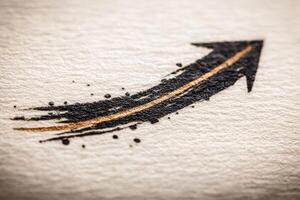 A sleek arrow graphic in black and gold features a textured paper background. The design conveys energy and movement, suitable for design projects and creative themes. photo